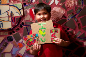 A child holds up mosaics he created at Philadelphia's Magic Gardens during an after school Encore event at Philadelphia's Magic Gardens.