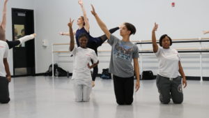 Students kneeling during dance rehearsal
