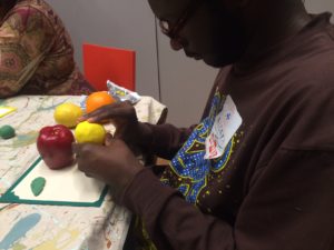 Overbrook School for the Blind student feeling the texture of several plastic fruits at a Barnes Foundation ArtSee event.