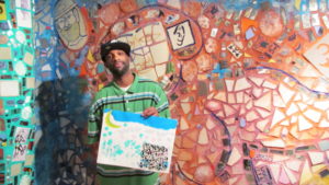 A man holds up his artwork at Philadelphia's Magic Gardens