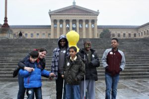 In photo: Overbrook school for the blind students posing in front of the Philadelphia Museum of Art. Between the buildings iconic columns reads “Go Eagles”